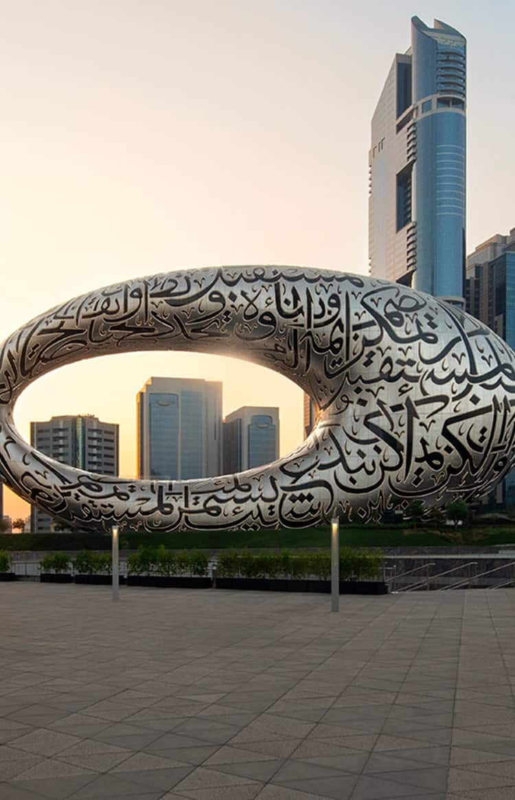 Museum of the Future with Dubai's skyline at sunset